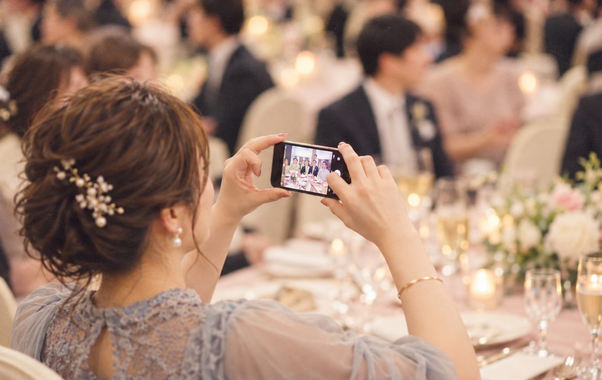 ゲストがスマホでテーブルの仲間を撮影している様子